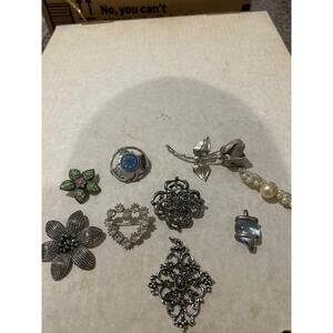 Lot of silver toned brooches and pendants